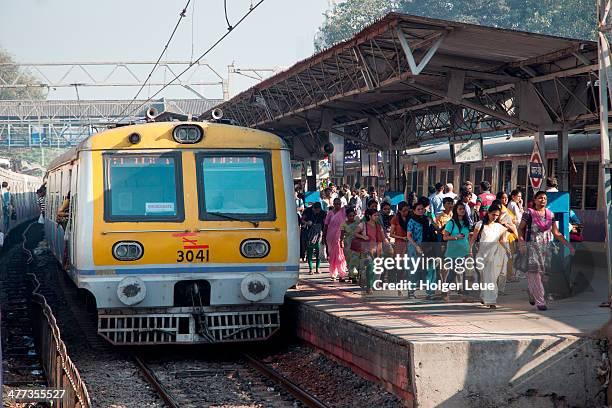 commuter train and people on railway platform - mumbai railway station stock pictures, royalty-free photos & images