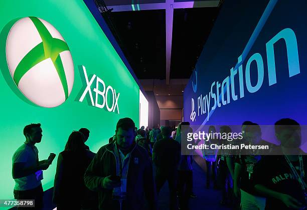 Game enthusiasts and industry personnel walk between the Microsoft XBox and the Sony PlayStation exhibits at the Annual Gaming Industry Conference E3...