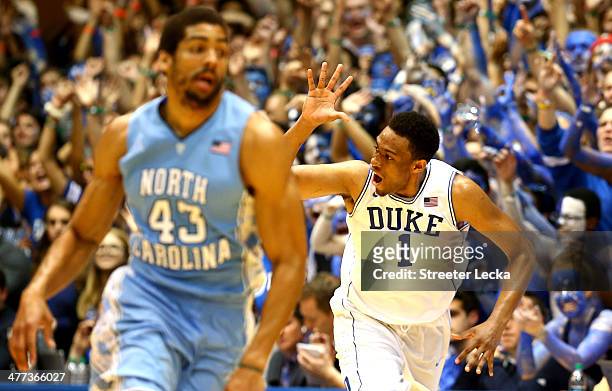 James Michael McAdoo of the North Carolina Tar Heels wtaches as Jabari Parker of the Duke Blue Devils reacts after making a basket during their game...