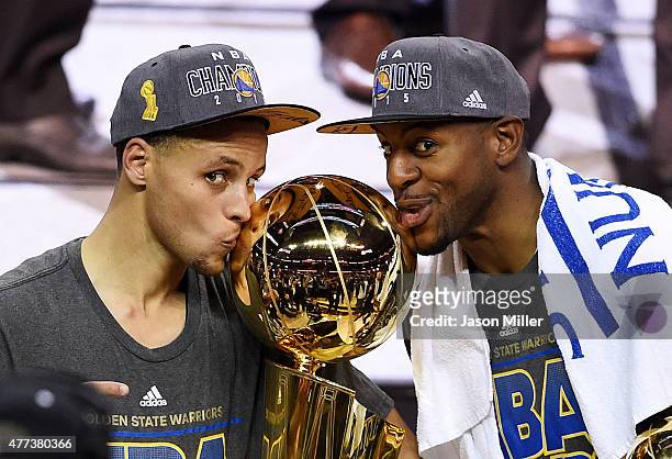 Stephen Curry and Andre Iguodala of the Golden State Warriors celebrate with the Larry O'Brien NBA Championship Trophy after defeating the Cleveland...