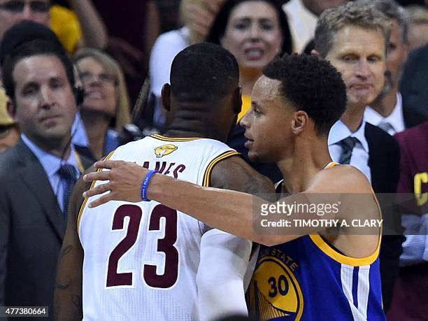 Stephen Curry of the Golden State Warriors embraces LeBron James of the Cleveland Cavaliers as James leaves the court in the final moments at the end...