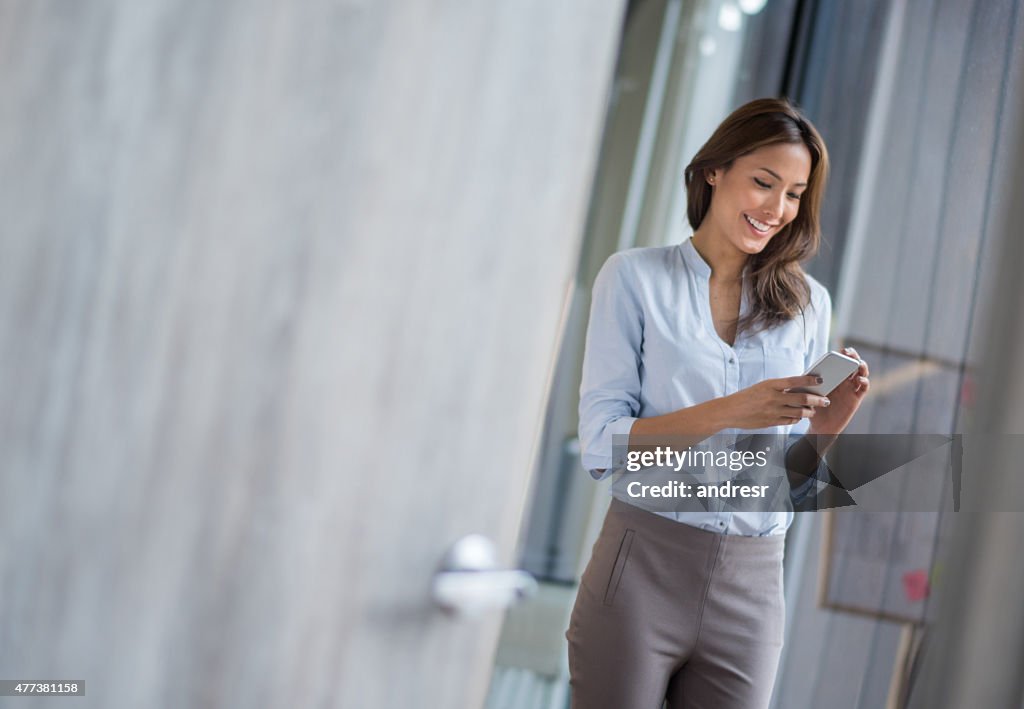 Femme d'affaires à envoyer des SMS sur son téléphone