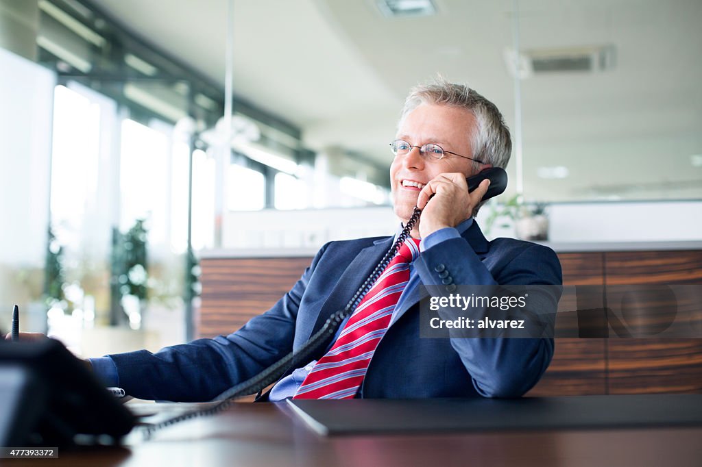 Heureux Homme d'affaires parlant à un collègue lors d'une réunion