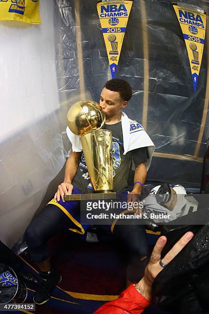Stephen Curry of the Golden State Warriors in the locker room kissing the Larry O'Brien Championship Trophy after the Golden State Warriors win Game...