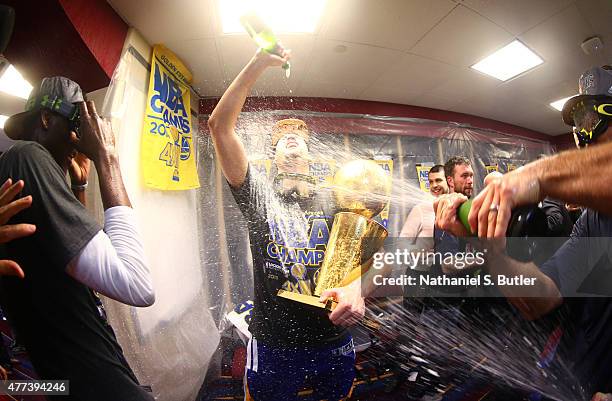 Klay Thompson of the Golden State Warriors reacts in the locker room while holding the Larry O'Brien Championship Trophy after the Golden State...