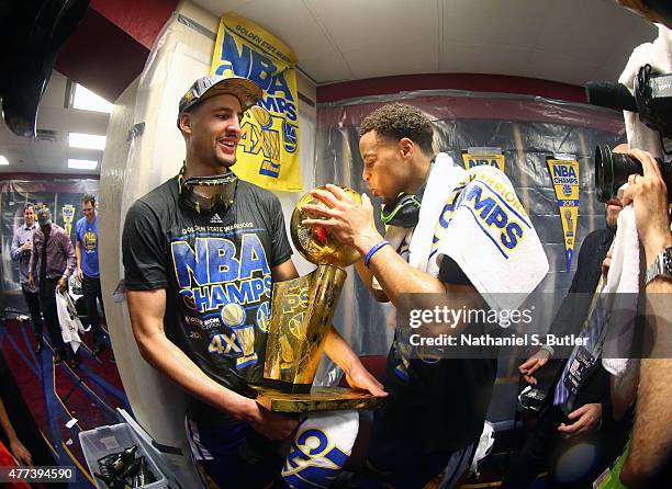 Teammates Klay Thompson of the Golden State Warriors and Stephen Curry of the Golden State Warriors smile in the locker room and kiss the Larry...