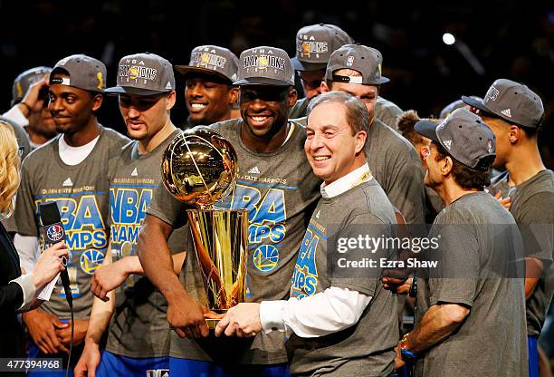 Draymond Green of the Golden State Warriors celebrates with team owner Joe Lacob and the Larry O'Brien NBA Championship Trophy after defeating the...