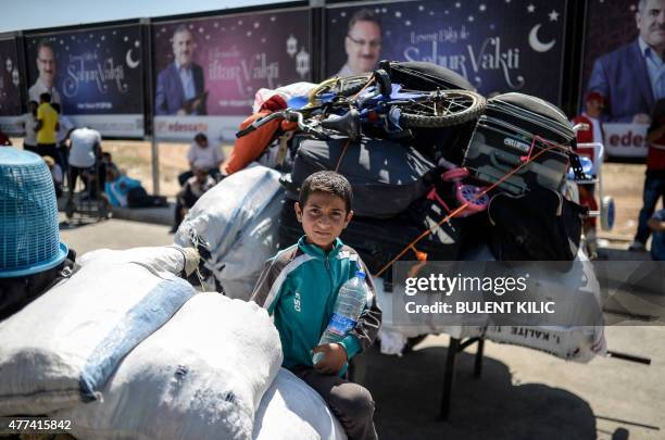 Syrian boy waits amongst belongings prior to go back to the northern Syrian town of Tal Abyad at the Turkish border post of Akcakale, the province of...