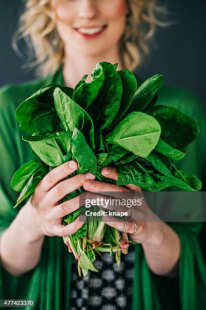 young woman holding spinach leafs salad - green leaf stock pictures, royalty-free photos & images