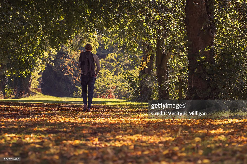 Woman walking through autumnal woodland