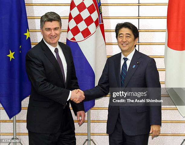 Croatian Prime Minister Zoran Milanovic and Japanese Prime Minister Shinzo Abe shake hand prior to their meeting at Abe's official residence on June...