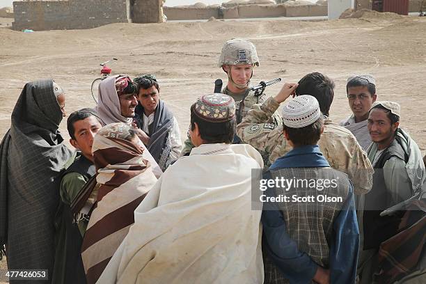 Ryan Spinuzzi-Nichols from Reno, Nevada with the U.S. Army's 4th squadron 2d Cavalry Regiment speaks with residents during a patrol through a village...