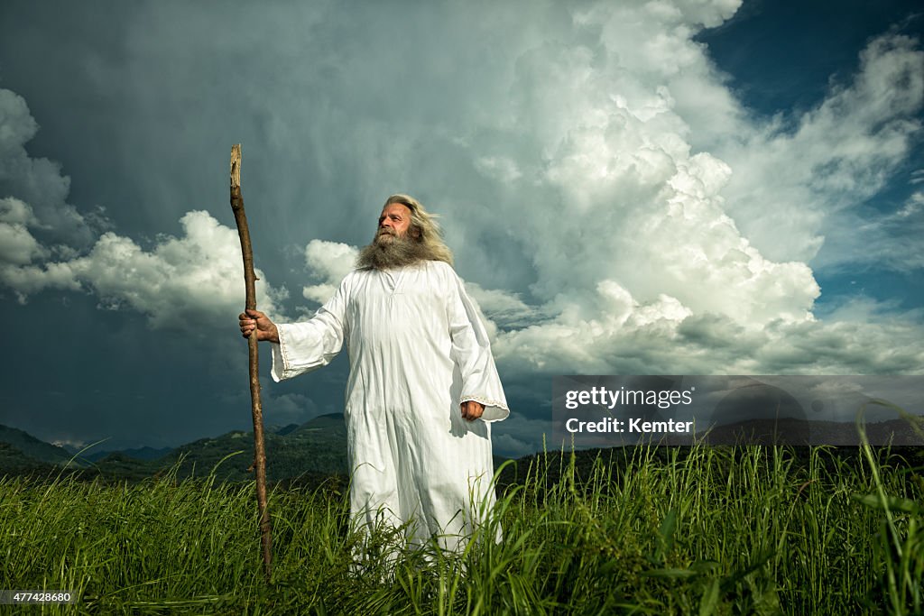 Long-haired prophet standing in front of dramatic sky