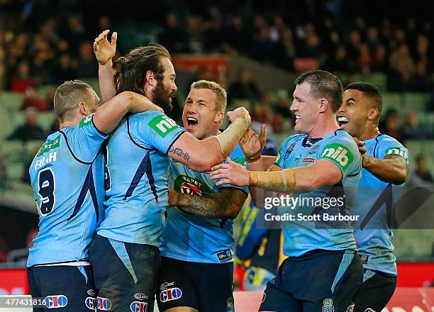 Aaron Woods of the Blues celebrates with Paul Gallen and his teammates after scoring a try during game two of the State of Origin series between the...