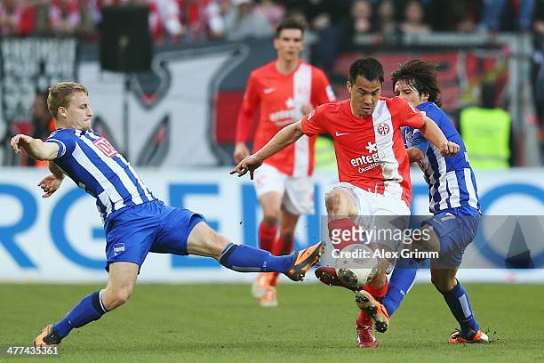 Shinji Okazaki of Mainz is challenged by Fabian Holland and Hajime Hosogai of Berlin during the Bundesliga match between 1. FSV Mainz 05 and Hertha...