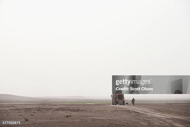 Air Force dog handler returns to his vehicle after a patrol with soldiers from the U.S. Army's 4th squadron 2d Cavalry Regiment on March 9, 2014 near...