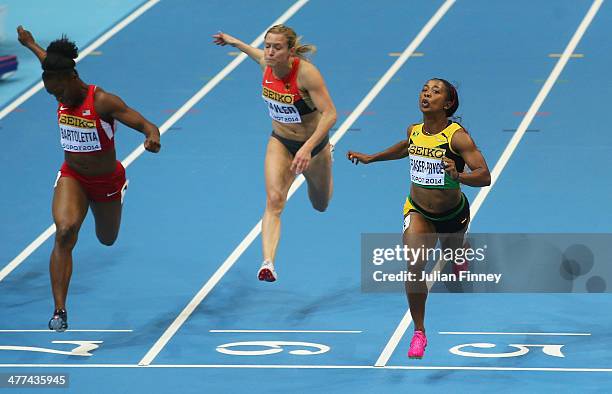 Shelly-Ann Fraser-Pryce of Jamaica crosses the line to win the gold medal with Tianna Bartoletta of the United States and Verena Sailer of Germany in...