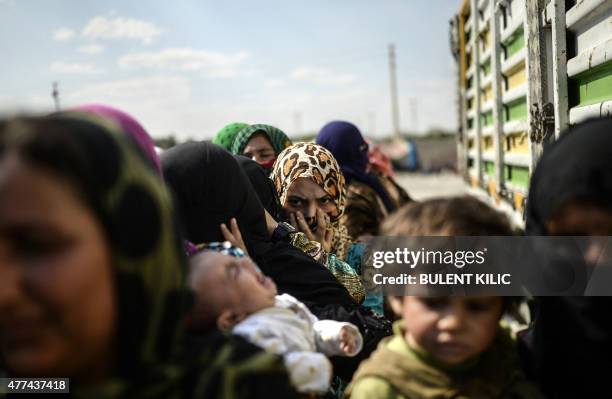 Syrian refugees wait for supply near the Turkish border post of Akcakale, province of Sanliurfa, on June 17, 2015. The first Syrian refugees returned...