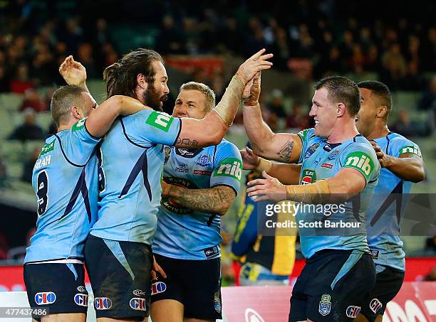 Aaron Woods of the Blues celebrates with Paul Gallen and his teammates after scoring a try during game two of the State of Origin series between the...