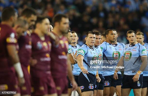 Paul Gallen of the Maroons and Blues looks over to Maroons players after players stand for the national anthem during game two of the State of Origin...