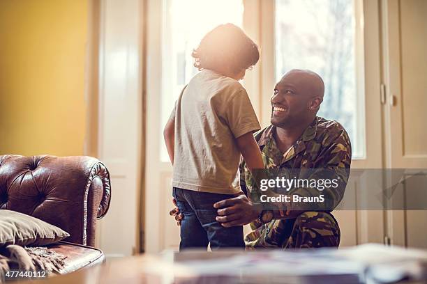 happy african american soldier talking to his son at home. - military family stock pictures, royalty-free photos & images