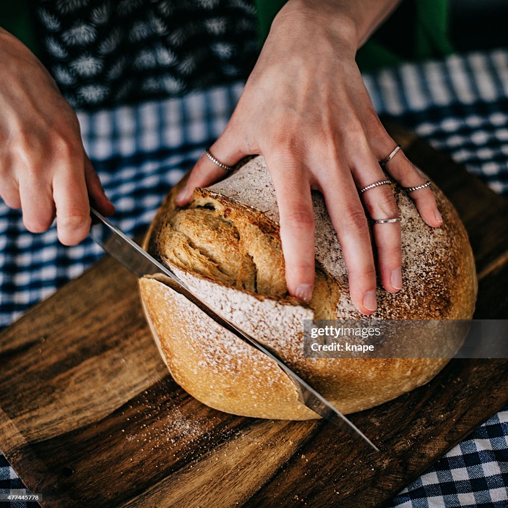 Junge Frau Schneiden frisches Brot