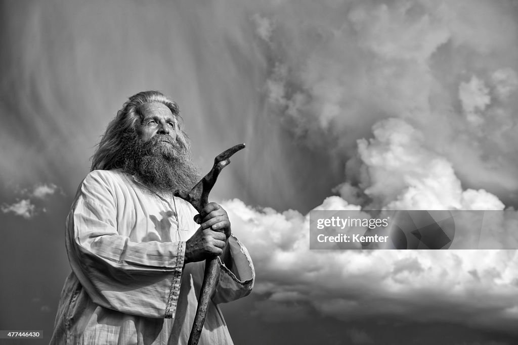 Long-haired prophet standing in front of dramatic sky