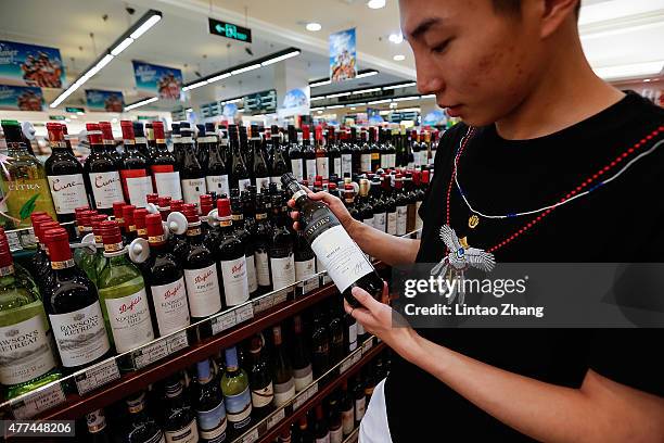 Customer selects a bottle of Australian wine at a supermarket on June 17, 2015 in Beijing, China. China's Minister of Commerce Gao Hucheng today is...