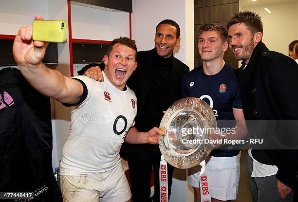 Dylan Hartley of England takes a photograph with team mate Owen Farrell and Manchester United footballers Rio Ferdinand and Michael Carrick during...