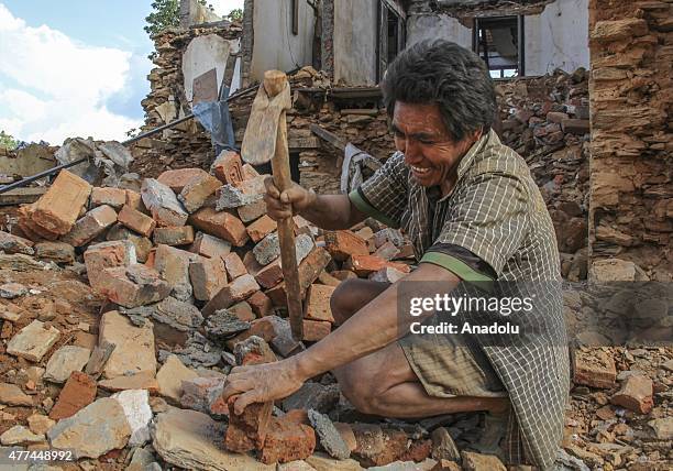 Nepalese man is seen on the debris of a collapsed building in the Sindhupalchowk district of Nepal on June 17, 2015. Rubble of buildings hasn't been...