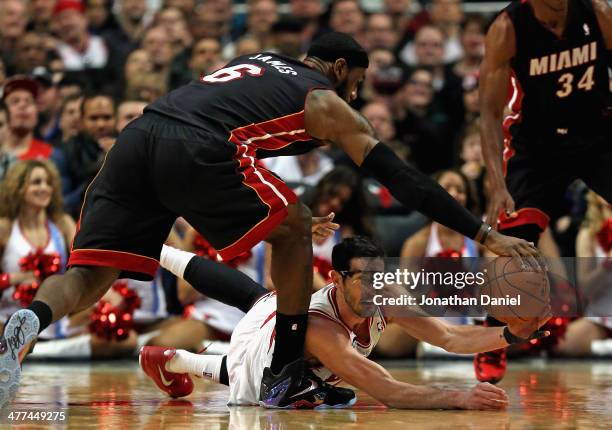 LeBron James of the Miami Heat tries to knock the ball away from Kirk Hinrich of the Chicago Bulls at the United Center on March 9, 2014 in Chicago,...