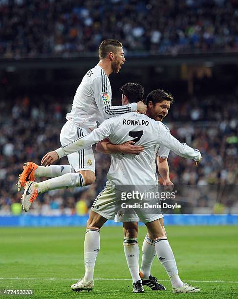 Cristiano Ronaldo of Real Madrid celebrates with Sergio Ramos and Xabi Alonso after scoring Real's opening goal during the La Liga match between Real...