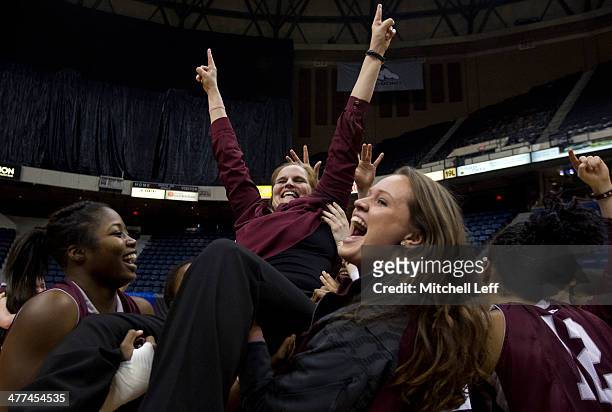 Head coach Stephanie Gaitley of the Fordham Rams is lifted in the air by her team in celebration of their win over the Dayton Flyers in the...