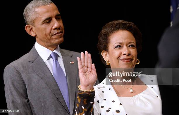 Attorney General Loretta Lynch is sworn in during a formal investiture ceremony as U.S. President Barack Obama looks on at the Warner Theatre June...