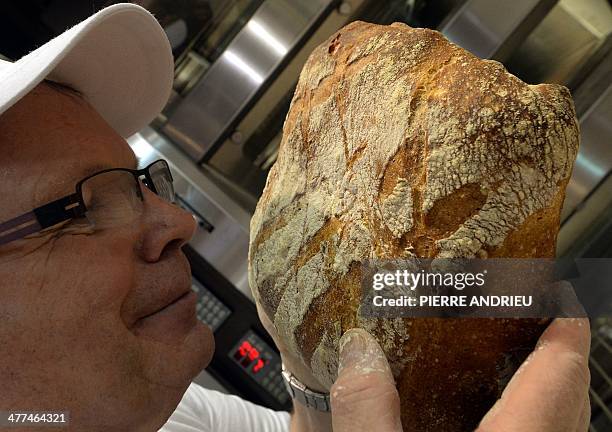 Baker smells a loaf of bread during Europain 2014, a World Bakery, Patisserie and Catering exhibition held in Villepinte, north of Paris, on March 9,...