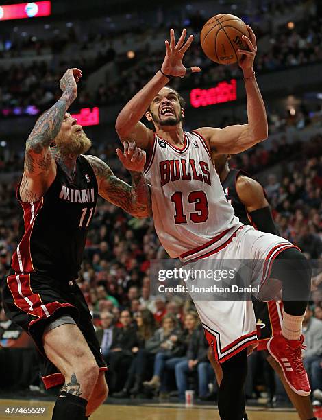 Joakim Noah of the Chicago Bulls drives to the basket against Chris Anderson of the Miami Heat at the United Center on March 9, 2014 in Chicago,...