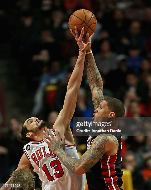 Joakim Noah of the Chicago Bulls blocks a shot by Michael Beasley of the Miami Heat at the United Center on March 9, 2014 in Chicago, Illinois. The...