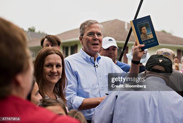 Jeb Bush, former governor of Florida and Republican 2016 U.S. Presidential candidate, comments on his likeness on a book cover handed to him for an...