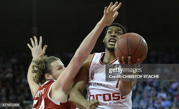 Bayern Munich's US center John Bryant and Bamberg's US guard Ryan Thompson vie for the ball during the fourth final play off match of the German...