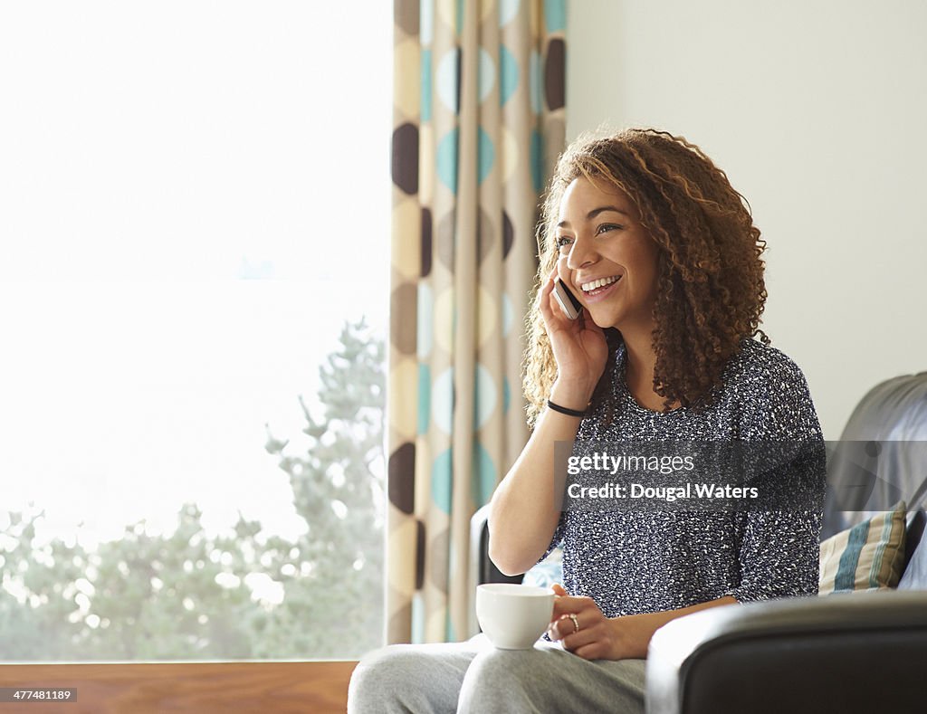 Using Phones In House Woman Using Mobile Phone At Home High-Res Stock Photo - Getty Images