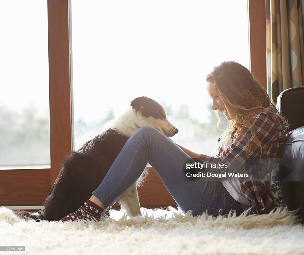 Profile of woman sitting in lounge with dog.