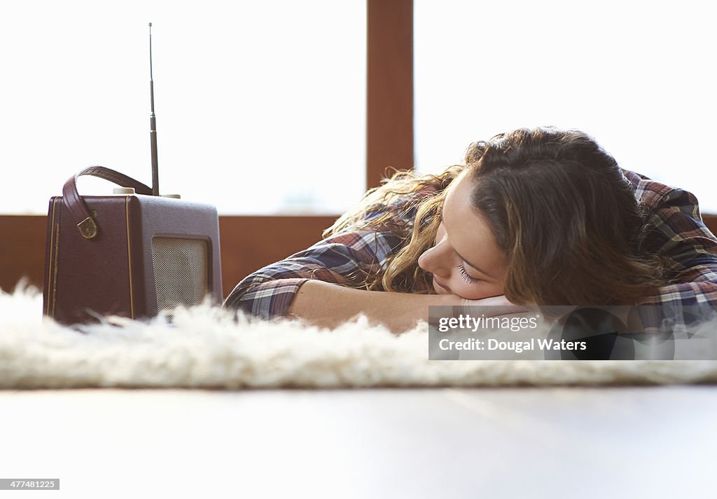 Woman laying down and listening to radio.