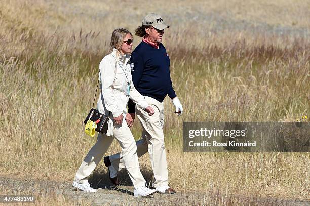 Miguel Angel Jimenez of Spain walks with his wife Susanne during a practice round prior to the start of the 115th U.S. Open Championship at Chambers...