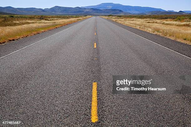 close up view of highway, mountains beyond - yellow line stockfoto's en -beelden