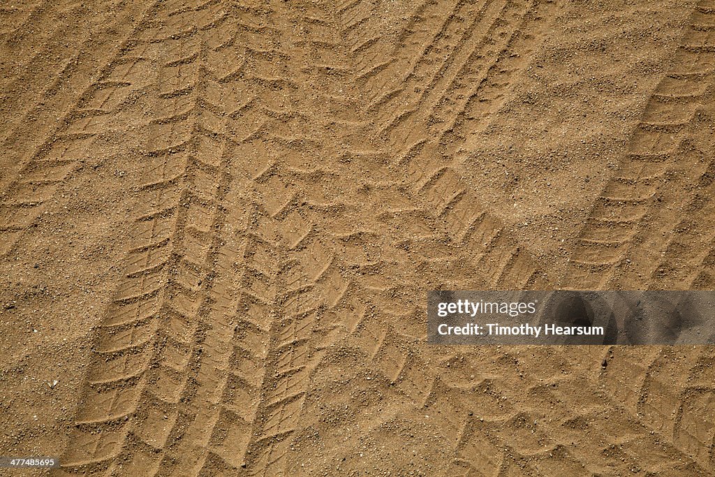 Close up of multiple tire tracks in the sand