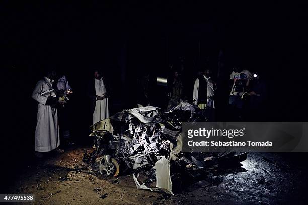 People view the remnants of a car-bomb used against Houthi officials' residences on June 17, 2015 in Sana'a, Yemen. News outlets have reported that...
