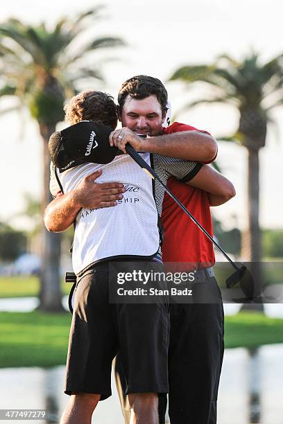 Patrick Reed hugs his caddie Kessler Karin after his victory in the final round of the World Golf Championships-Cadillac Championship at Blue...