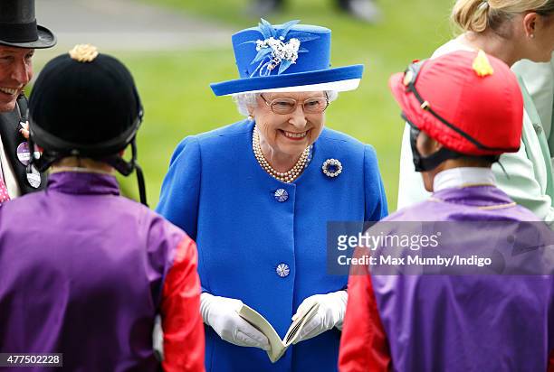 Queen Elizabeth II talks with jockeys Jamie Spencer and Sean Levey prior to them riding her horses 'Touchline' and 'Pack Together' in The Sandringham...