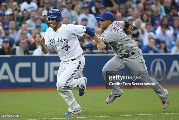 Danny Valencia of the Toronto Blue Jays is tagged out by Ruben Tejada of the New York Mets as he is caught in a run-down between home plate and third...