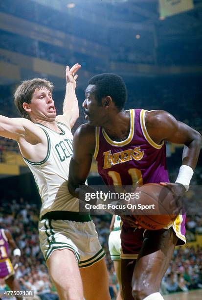 Danny Ainge of the Boston Celtics guards Bob McAdoo of the Los Angeles Lakers during an NBA basketball game circa 1985 at the Boston Garden in...